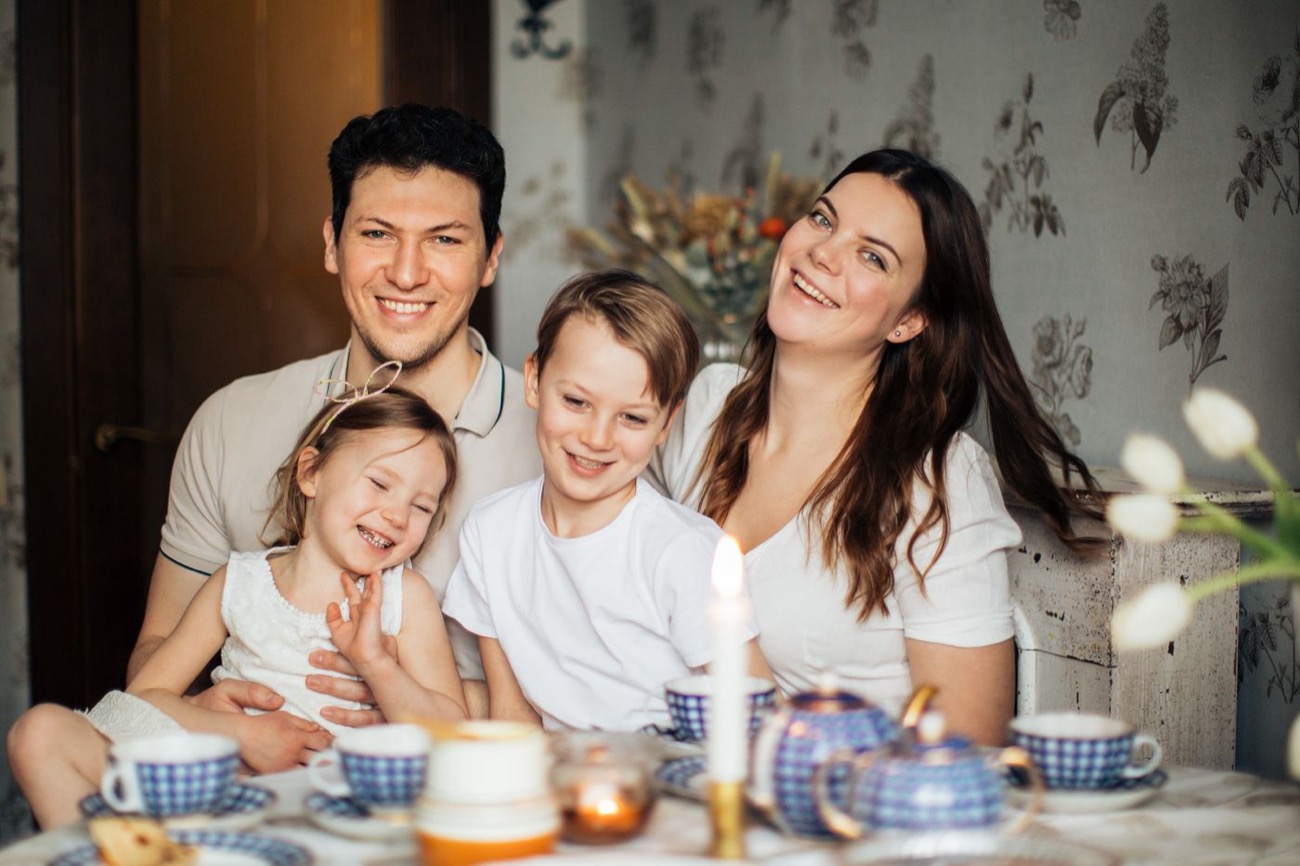 Two parents with a young boy and girl sitting together at a breakfast table at home